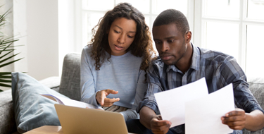 Couple looking at mortgage and laptop