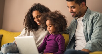 Young family with toddler looking at a tablet