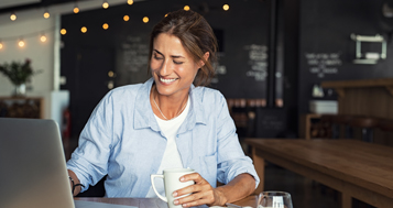 Woman on laptop drinking coffee